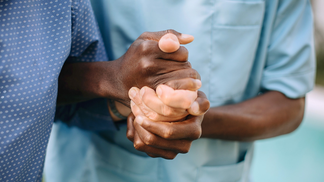 Two people hold hands