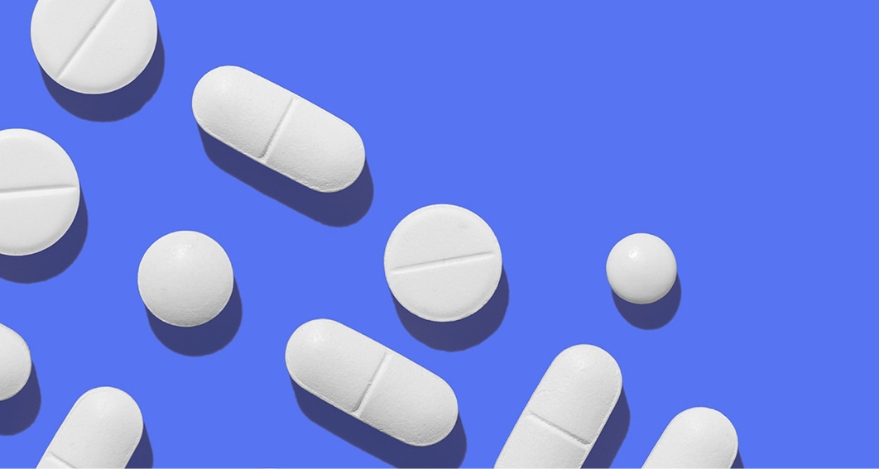 Several unlabeled pills scattered across a blank background