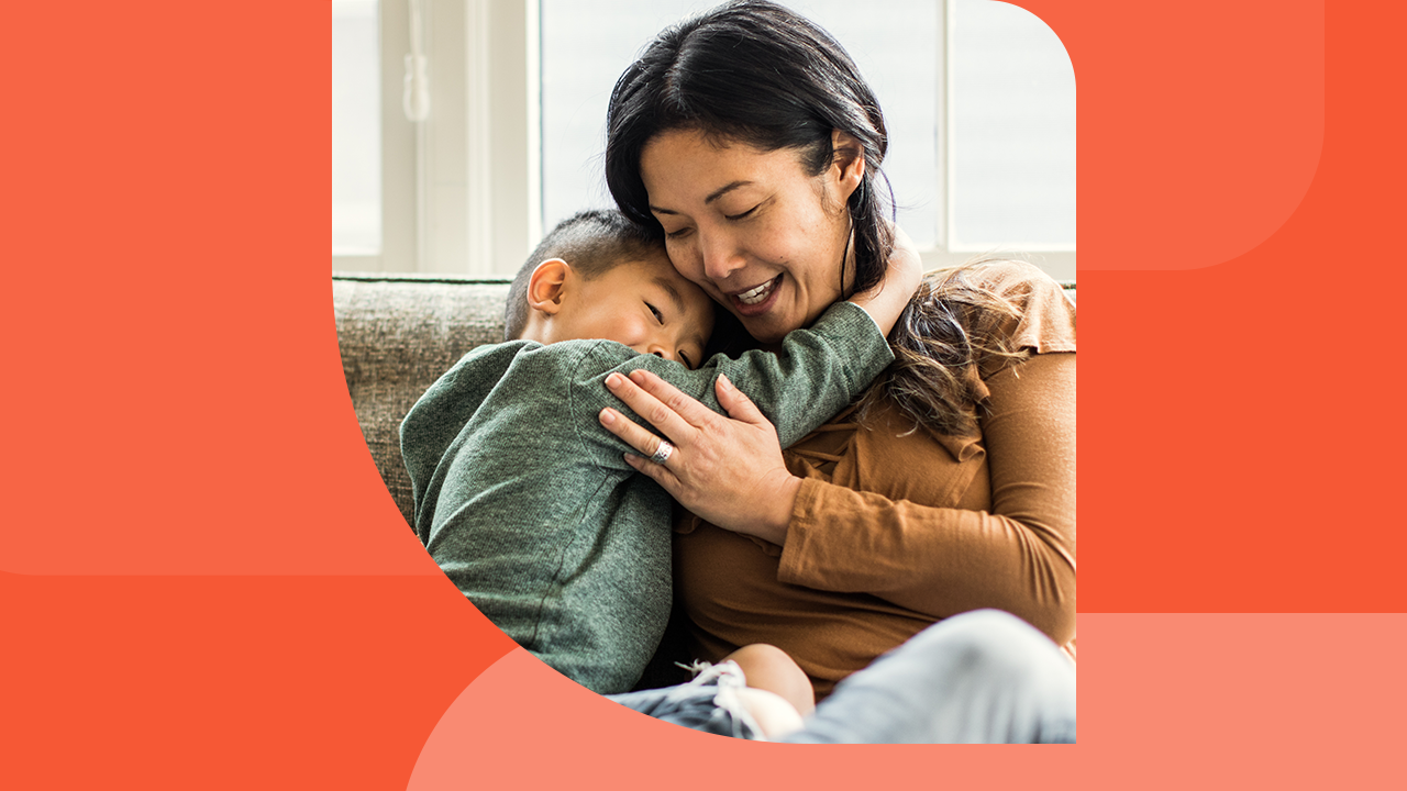 A woman hugs a young child.