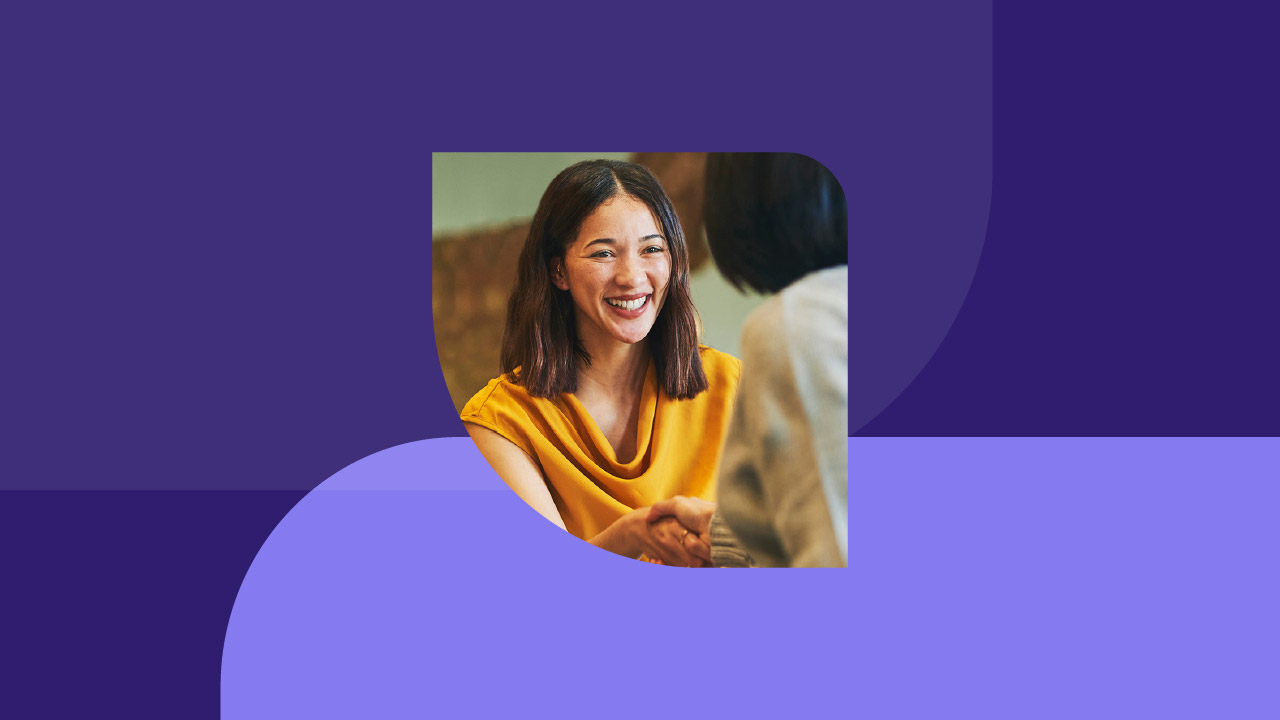 A woman shakes the hand of another woman