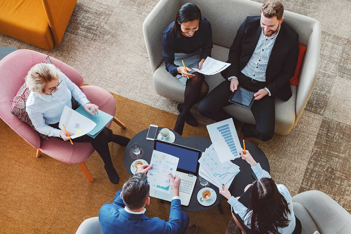 People sitting around a table with paperwork and snacks