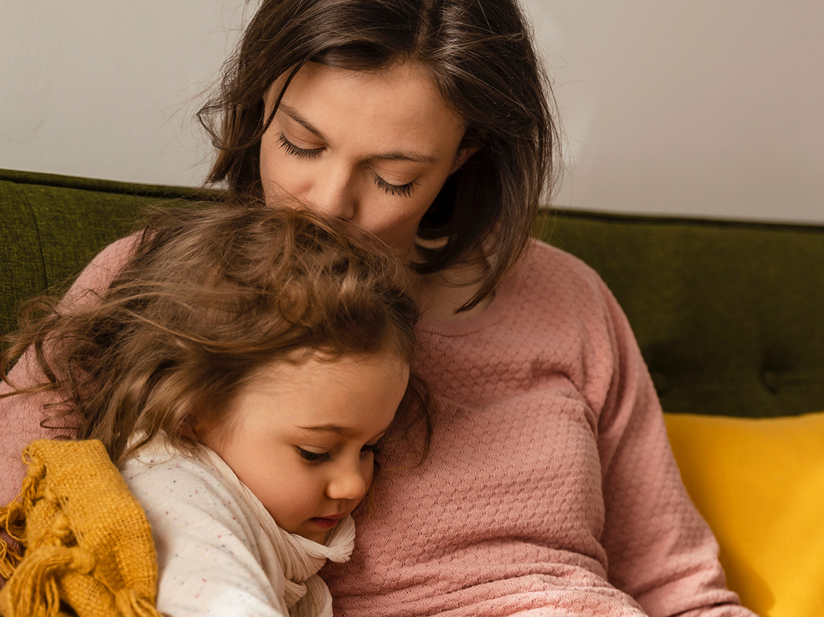 Picture of woman holding child sitting together on a couch