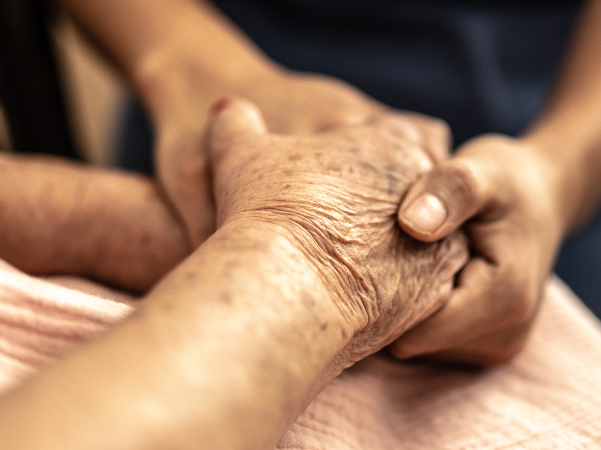 Close up image of two individuals holding hands